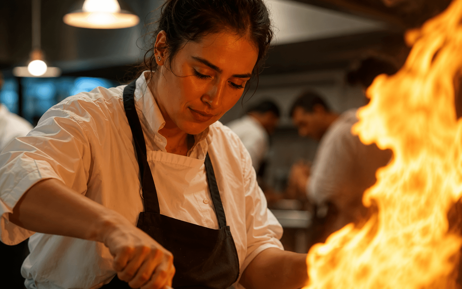 Chef cooking over an open flame in the Piquant kitchen